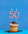 Birthday candle with cupcake on blue background - Number 50