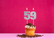 Birthday celebration with candle number 59 - Chocolate cupcake on pink background