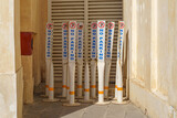 Fototapeta Do pokoju - Close-up view of several plastic signs, pillars with a no parking sign standing in a corner of the street in the Souq Waqif bazaar area, at daytime, Doha, Qatar