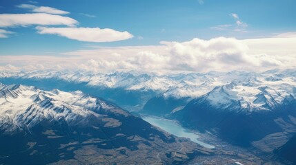 Wall Mural - This is an aerial shot of the Swiss Alps. The snow-capped mountains are stunning, and the blue sky is dotted with clouds.