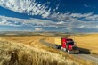 Truck driving on road with wheat fields and clouds backdrop