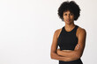 Biracial female yoga instructor standing in studio with arms crossed, looking serious, copy space