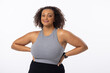 Biracial young female plus size model with hands on hips, standing confidently on white background