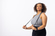 Biracial young female plus size model holding resistance band, looking confident on white background