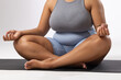 Biracial young female plus size model sitting cross-legged, practicing yoga on white background
