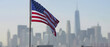 waving flag of united states with city in background