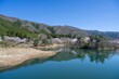 青空バックに見る満開の桜に囲まれた大野ダムの情景