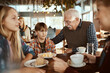 © Davor - Grandparents with grandchildren at cafe table