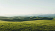 Panoramic view of gentle rolling green hills under a clear blue sky in a minimalist landscape