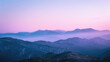 Serene mountain silhouettes cast in soothing purple hues of dusk