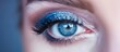 A detailed view of a female eye highlighting the blue eyeliner makeup applied with precision and flair