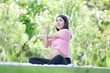 Asian pregnant woman meditating while sitting in the park, woman doing stretching exercises outdoors, Meditating on maternity