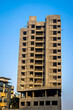 Clear blue sky behind two tall buildings in Sunlight , under construction in fast growing city of Pune, India