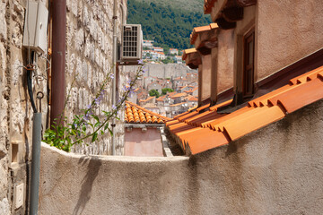 Canvas Print - Hillside homes through view-shaft between apartment buildings and orange rooftop tiles