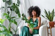 Radiant Woman in Green Dress Laughing Among Indoor Plants in a Bright Room
