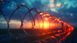Barbed wire coils against a sunset background. Security and boundary concept with an element of freedom. Design for diverse uses from warning signs to metaphorical art. Bokeh effect with warm tones