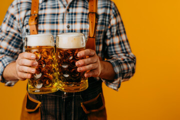 Wall Mural - Charming young Oktoberfest server in traditional Bavarian attire with large beer steins against a yellow background