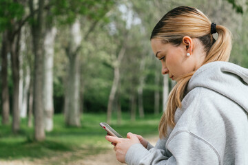 Close-up of hiker texting on his mobile phone on a field trip