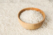 Raw basmati rice and bowl as background, closeup. Space for text