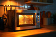 modern stainless steel heavy microwave oven with digital display on wooden table in kitchen at home