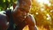 Fit sporty young African man wearing black sportswear relaxing after workout in urban park on summer day Strong muscular guy bodybuilder sweating sport street training outdoors closeup : Generative AI