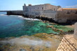 The fortifications of Castello Maniace (Maniace Castle) in Ortigia Island, Syracuse, Sicily, Italy, with clear and colorful water