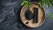 Flat lay of activated charcoal sticks and powder displayed on a round wooden dish Activated charcoal helps detoxify and absorb excess oil : Generative AI