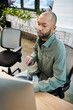 © Bliss - disabled african american man with myasthenia gravis in front of a laptop, focused on work in a bustling office environment filled with corporate culture.