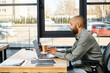 © Bliss - A man engrossed in work, using a laptop computer at a desk in a corporate office.