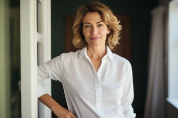 Wall Mural - Portrait of a tender woman in her 40s wearing a classic white shirt in front of stylized simple home office background