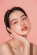 © Nia™ - Young Asian beauty woman pulled back hair with korean makeup style touch her face and perfect skin on isolated one color background - generative ai