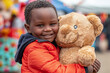 Young Boy Smiling with Large Teddy Bear at Outdoor Event