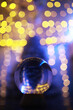 Crystal Ball on the floor with bokeh, lights behind. Glass ball with colorful bokeh light, new year celebration concept.