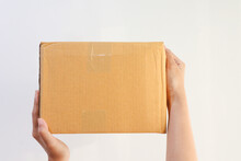 Young Woman Holding Cardboard Box On White Background.