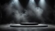 A spotlight shines on an empty stage surrounded by smoke.

