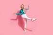 Full size photo of pretty young girl raise hands dance look empty space wear trendy striped cyan outfit isolated on pink color background