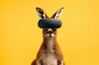 Portrait of a funny kangaroo in virtual reality glasses on yellow background. Studio shot	
