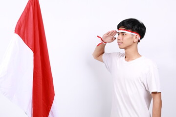 Indonesian youth standing while saluting the flag. Isolated on white background