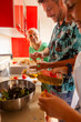 © ADDICTIVE STOCK - Family cooking together in a vibrant kitchen