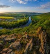 Spring sunset over meander of river Hron in Slovakia from extinct volcano, biotope of rare plants and flowers. Krivin, Hronsky Benadik. Discover the spring beauty of the mountains and rivers.