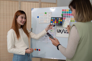 Wall Mural - ux developer and ui designer presenting mobile app interface design on whiteboard in meeting at offi