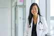 Asian female doctor in a white coat with stethoscope in a hospital.