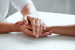© peopleimages.com - Hands, support and hope for console or care on table, comfort empathy for bad news or illness. Closeup, people and unity in crisis by prayer, trust or bond for person suffering with diagnosis