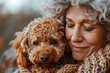 Mature beautiful woman cuddling her curly cute dog. Adopt Dog concept.