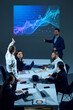 © master1305 - Colleagues in a corporate environment examine digital stock chart projected on screen in the boardroom. Investment strategies and market analysis. Concept of business, trade market, economic, finances