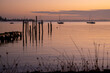© Austockphoto - Poles from old heritage wharf in a bay at sunrise with moored yachts in the background