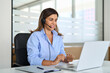 Busy middle aged female support service operator talking to customer sitting at desk. Happy mature woman professional call contact center agent wearing headset working in business office using laptop.