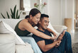 © peopleimages.com - Couple, house and happy with tablet for search on sofa with pointing for decision for buying. Online shopping, furniture and tech with thinking for choice with positivity, togetherness and bonding