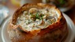 A hearty bowl of creamy clam chowder served in a bread bowl, representing the comforting and soul-warming soups of Western culinary tradition.
