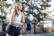© Mat Hayward - Asian woman playing pickleball on a court with her paddle outside. The female player is strong and plays hard.